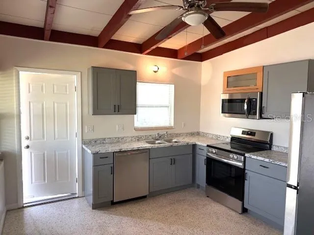 a view of a hallway with a refrigerator and a chandelier