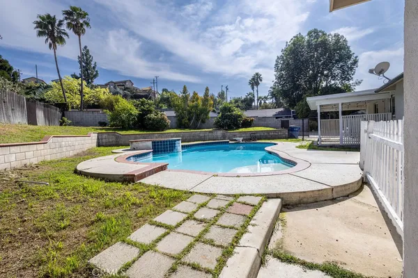 swimming pool view with a seating space and a garden