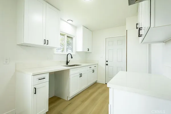 a kitchen with a sink cabinets and wooden floor