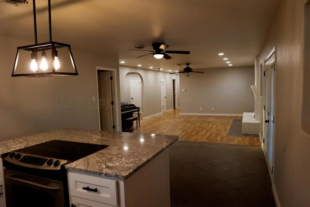 a kitchen with kitchen island granite countertop a stove and a sink