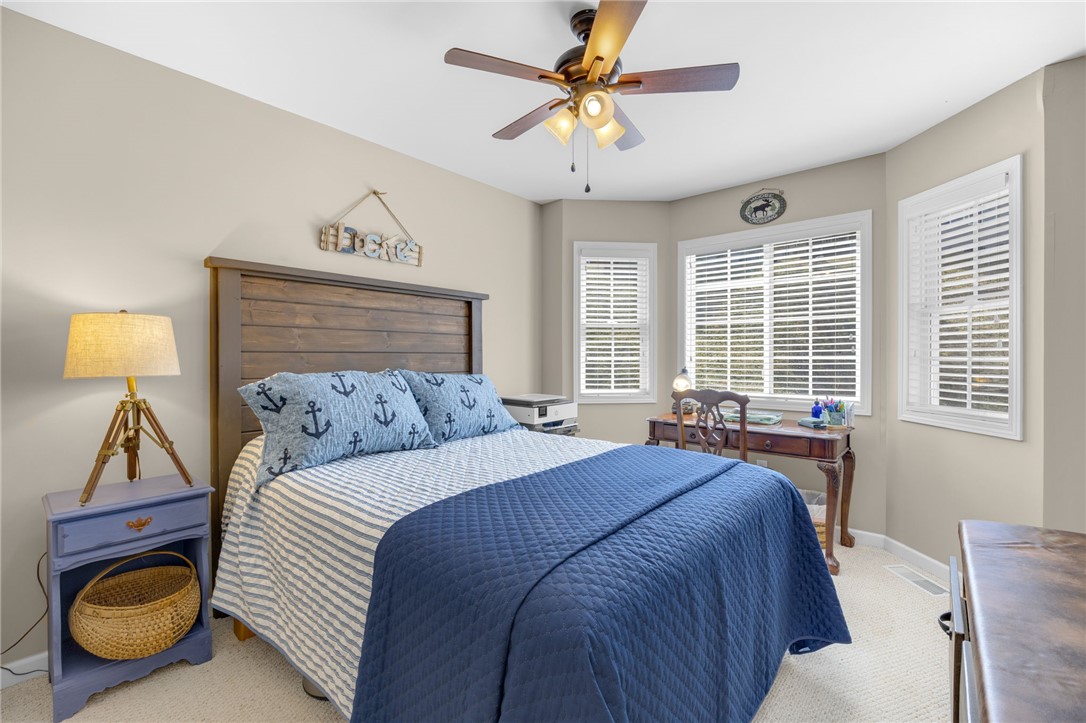 1230 Melton Road, Unit 93 West Union, SC 29696 - Photo 24 of 45 This cozy bedroom features bright windows, a warm wood headboard, and soft carpet.