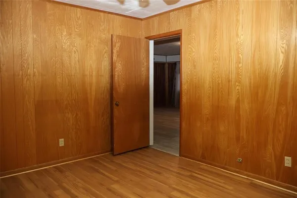 an empty room with wooden floor and closet