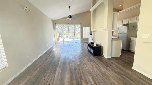 a view of empty room with wooden floor and window