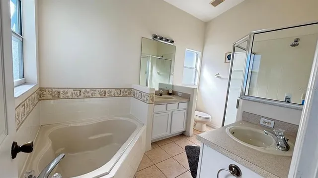 a bathroom with a tub a sink and a mirror