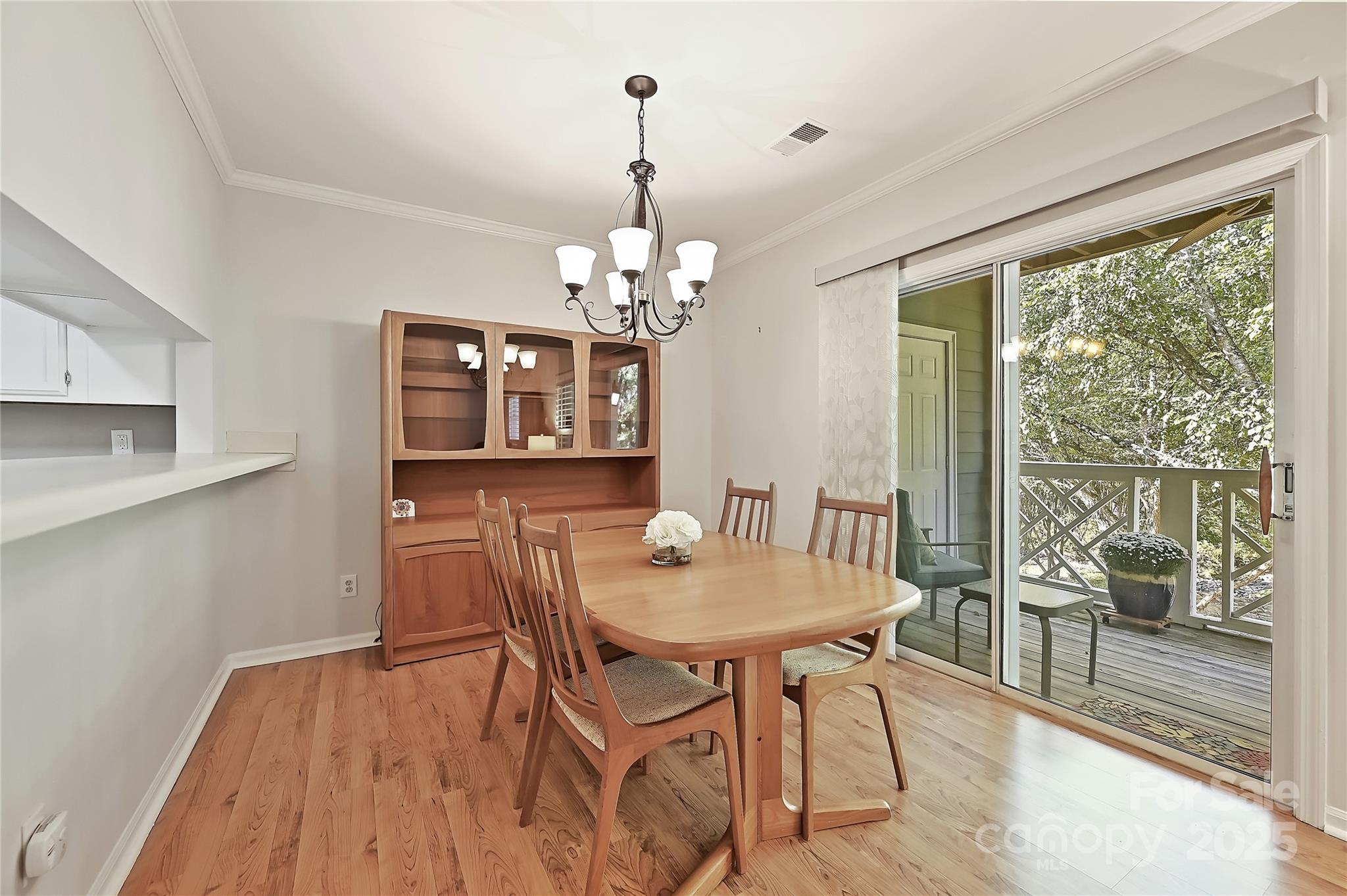 19901 Henderson Road, Unit C Cornelius, NC 28031 - Photo 14 of 42 a dining room with wooden floor a chandelier a wooden table and chairs