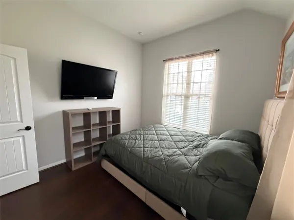 a bedroom with a bed and a flat screen tv
