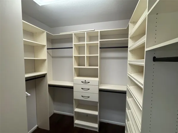 a view of walk in closet with empty racks