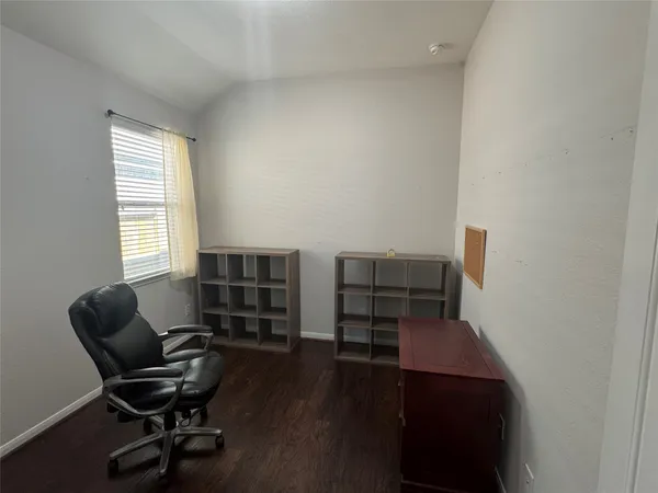 a view of a workspace with furniture and a window
