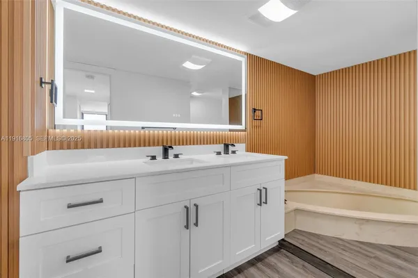 a bathroom with a tub sink and a mirror