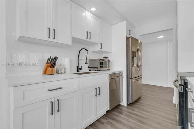 a kitchen with stainless steel appliances a refrigerator sink and cabinets