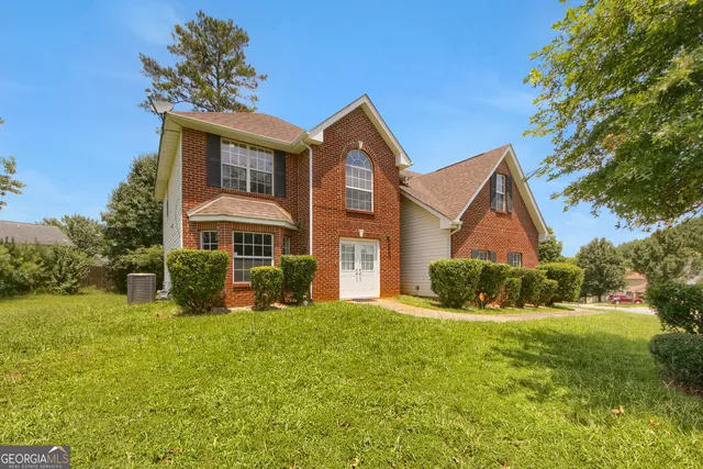 a front view of a house with yard and green space