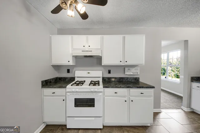 a kitchen with cabinets appliances a sink and a stove