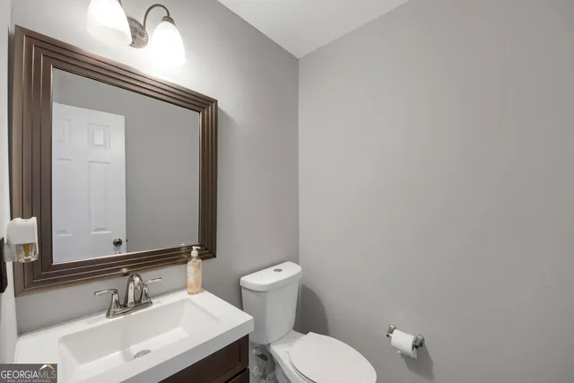 a bathroom with a toilet a sink and mirror