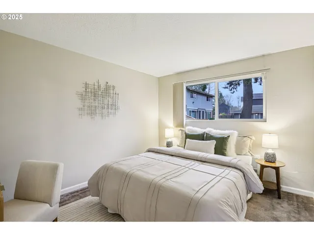 a bedroom with a bed and a painting on the wall
