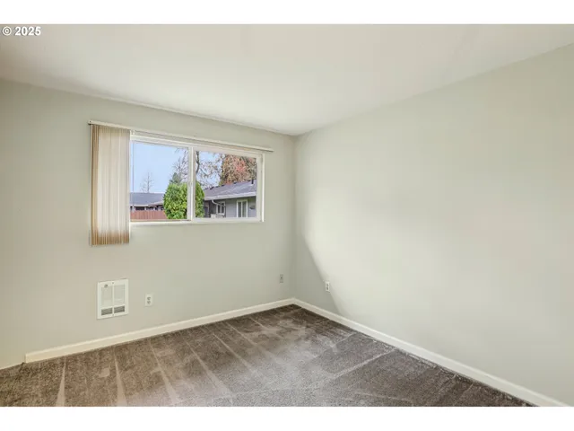 an empty room with wooden floor and window