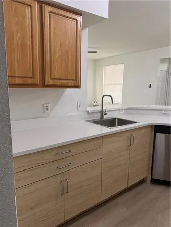 a kitchen with white cabinets and sink