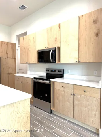 a kitchen with stainless steel appliances a stove a sink and a microwave
