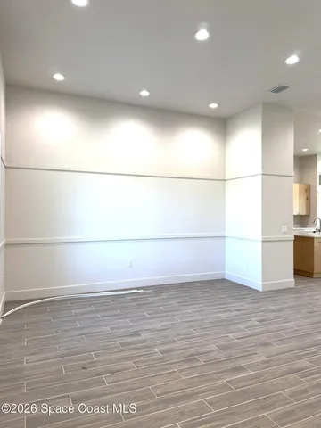 a view of a room with an empty space and wooden floor