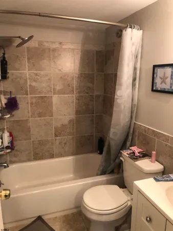 a white toilet sitting next to a bath tub and a shower