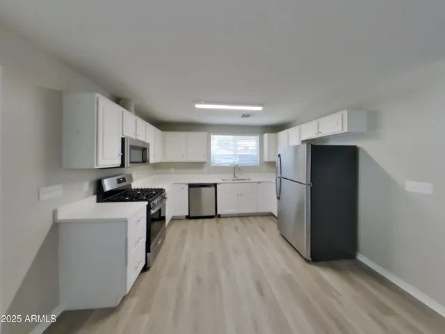 a view of a kitchen with a sink and dishwasher cabinets