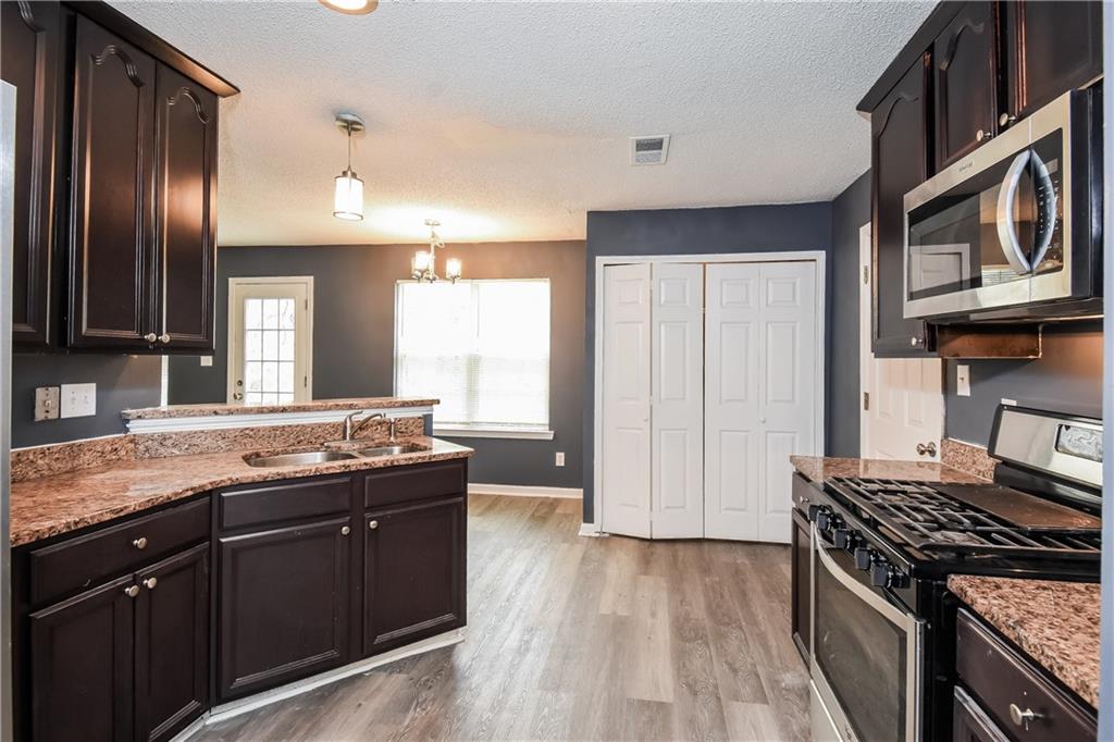 2716 River Tree Drive Decatur, GA 30034 - Photo 11 of 27 a kitchen with stainless steel appliances granite countertop a stove a sink and a refrigerator