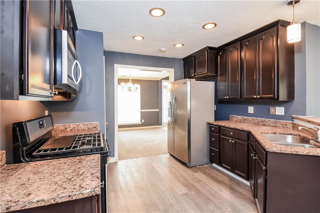 2716 River Tree Drive Decatur, GA 30034 - Photo 12 of 27 a kitchen with granite countertop stainless steel appliances a refrigerator and a stove