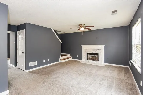 a view of a livingroom with a fireplace and window