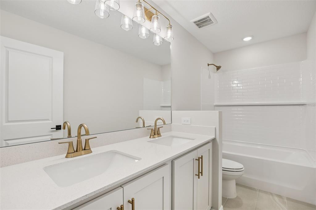 10167 Hidden Hammock Loop Parrish, FL 34221 - Photo 31 of 42 a bathroom with a sink a toilet a shower and a mirror