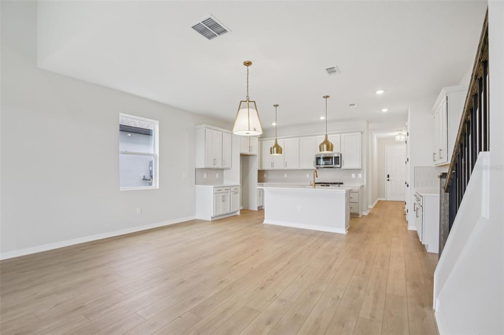 10167 Hidden Hammock Loop Parrish, FL 34221 - Photo 6 of 42 a open kitchen with white cabinets and wooden floor