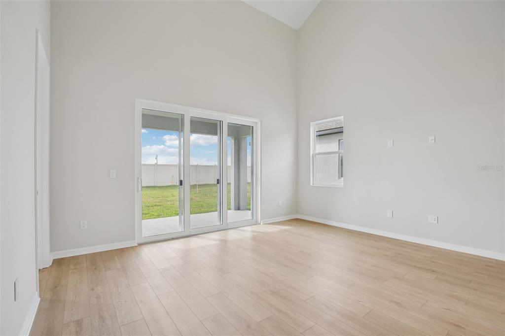 10167 Hidden Hammock Loop Parrish, FL 34221 - Photo 8 of 42 an empty room with wooden floor and windows