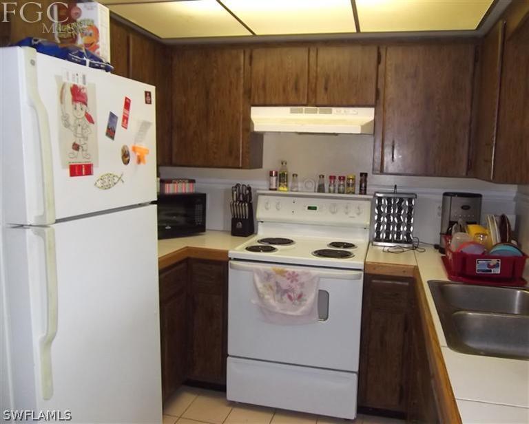 7310 Coon Road North Fort Myers, FL 33917 - Photo 3 of 10 a kitchen with a refrigerator and a stove
