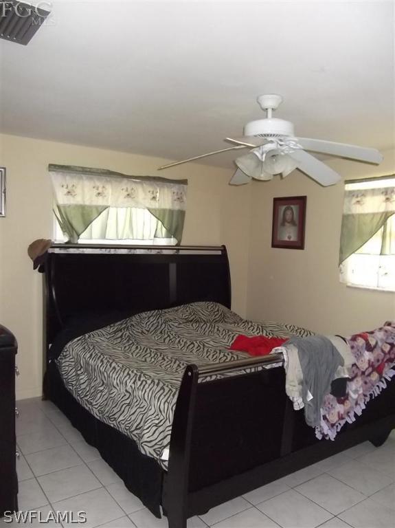 7310 Coon Road North Fort Myers, FL 33917 - Photo 4 of 10 a bedroom with a bed and a chandelier