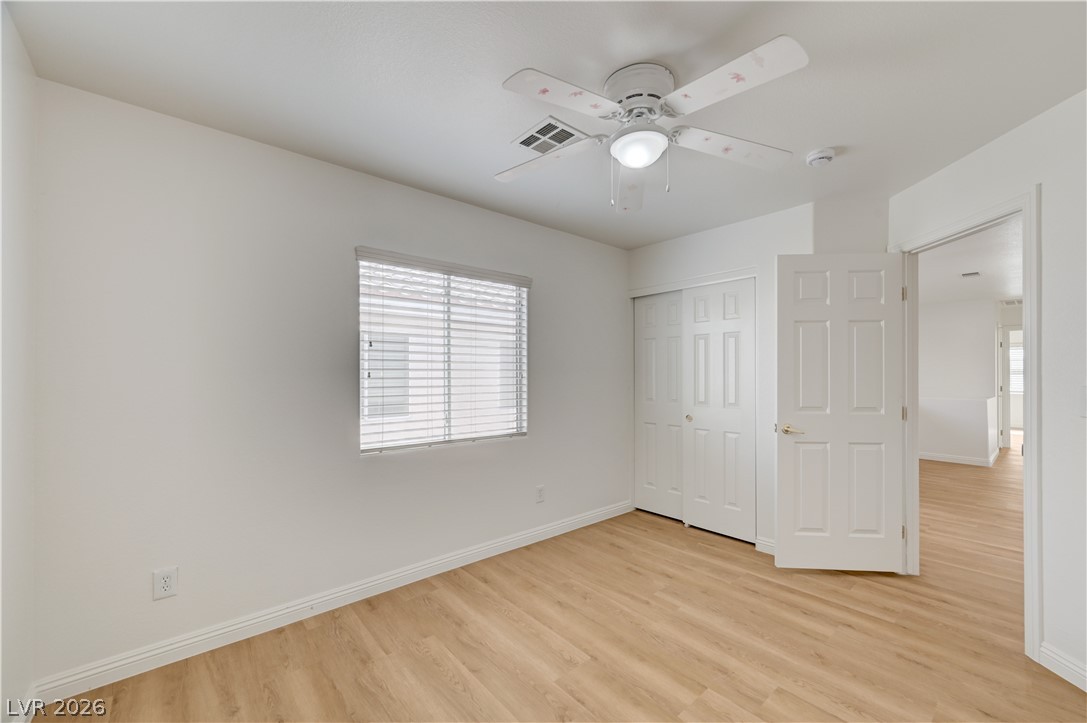 8918 Houston Ridge Avenue Las Vegas, NV 89178 - Photo 23 of 35 A well-lit bedroom features durable laminate flooring and a ceiling fan for comfort.