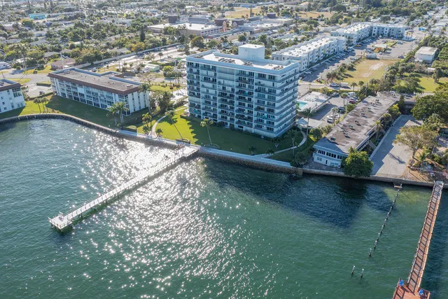 an aerial view of residential houses with outdoor space and lake view