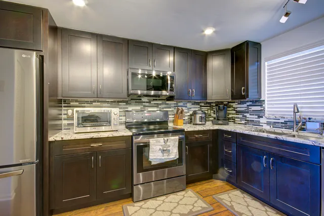 a kitchen with stainless steel appliances granite countertop a sink stove and refrigerator