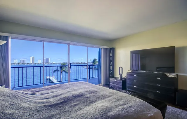 a bedroom with a bed and a flat tv screen on dresser