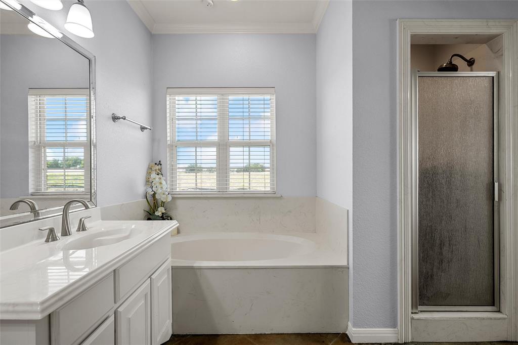 3696 Old Lorena Road Lorena, TX 76655 - Photo 18 of 27 Bathroom featuring a built-in soaking tub, a separate shower enclosure with a frosted glass door, a vanity with an integrated sink, and a framed mirror