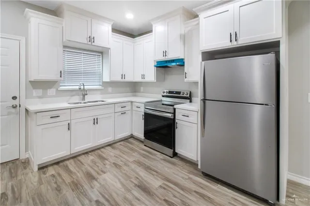 a kitchen with a refrigerator stove and sink