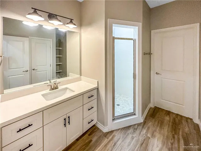a bathroom with a double vanity sink and mirror with shower