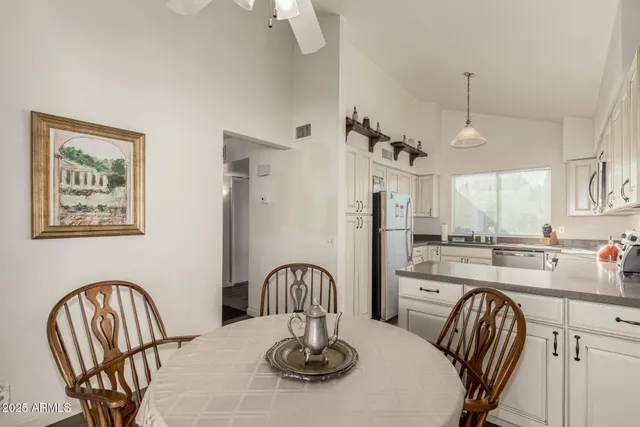 a kitchen with stainless steel appliances a table and chairs