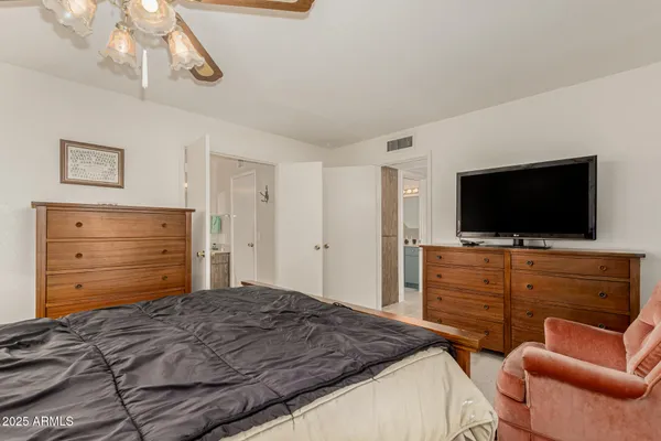 a bedroom with a bed and a flat screen tv