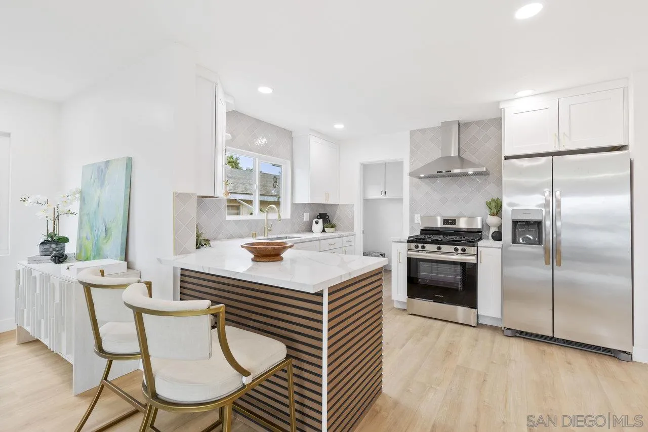 1320 Higgins Street Oceanside, CA 92058 - Photo 14 of 25 a kitchen with kitchen island a stove a refrigerator a dining table and chairs