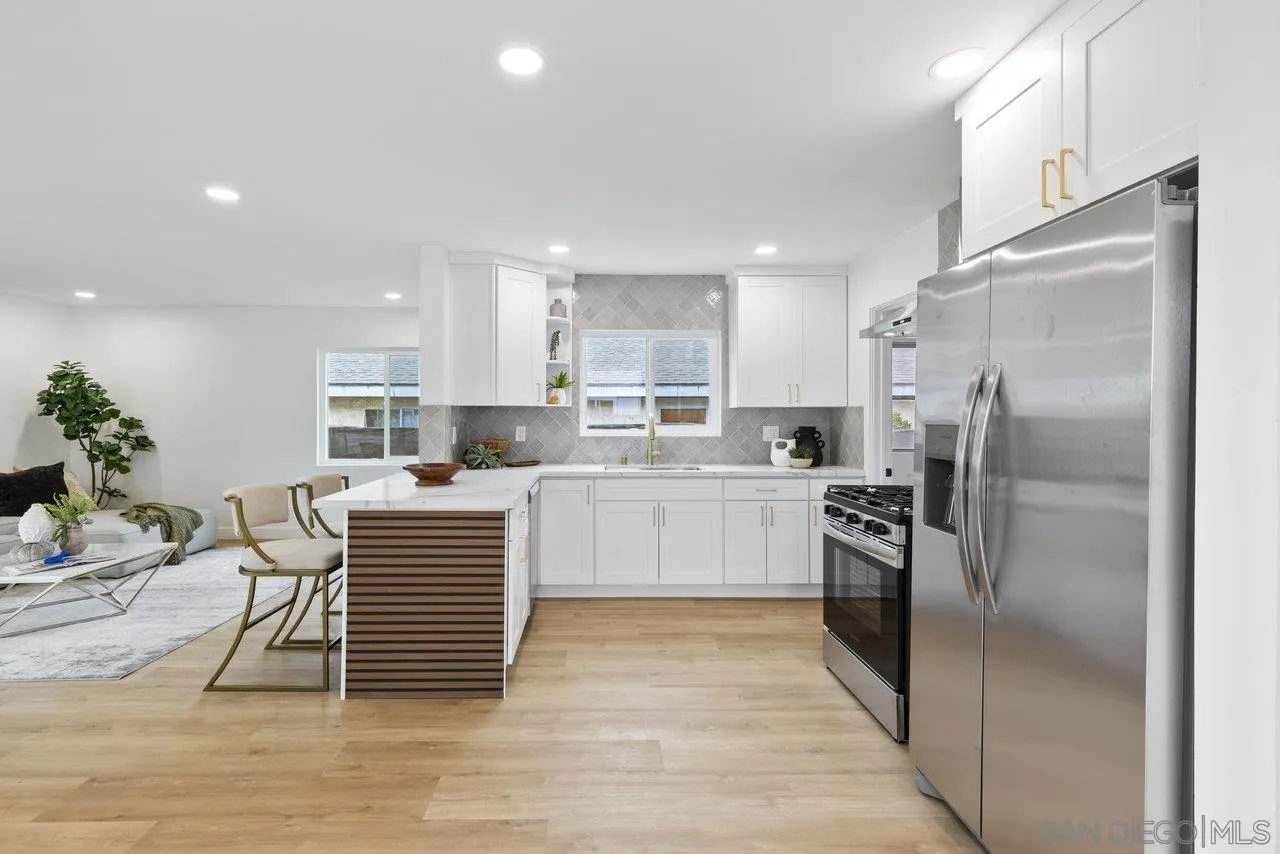 1320 Higgins Street Oceanside, CA 92058 - Photo 15 of 25 a kitchen with stainless steel appliances kitchen island granite countertop a refrigerator oven a sink a dining table and chairs