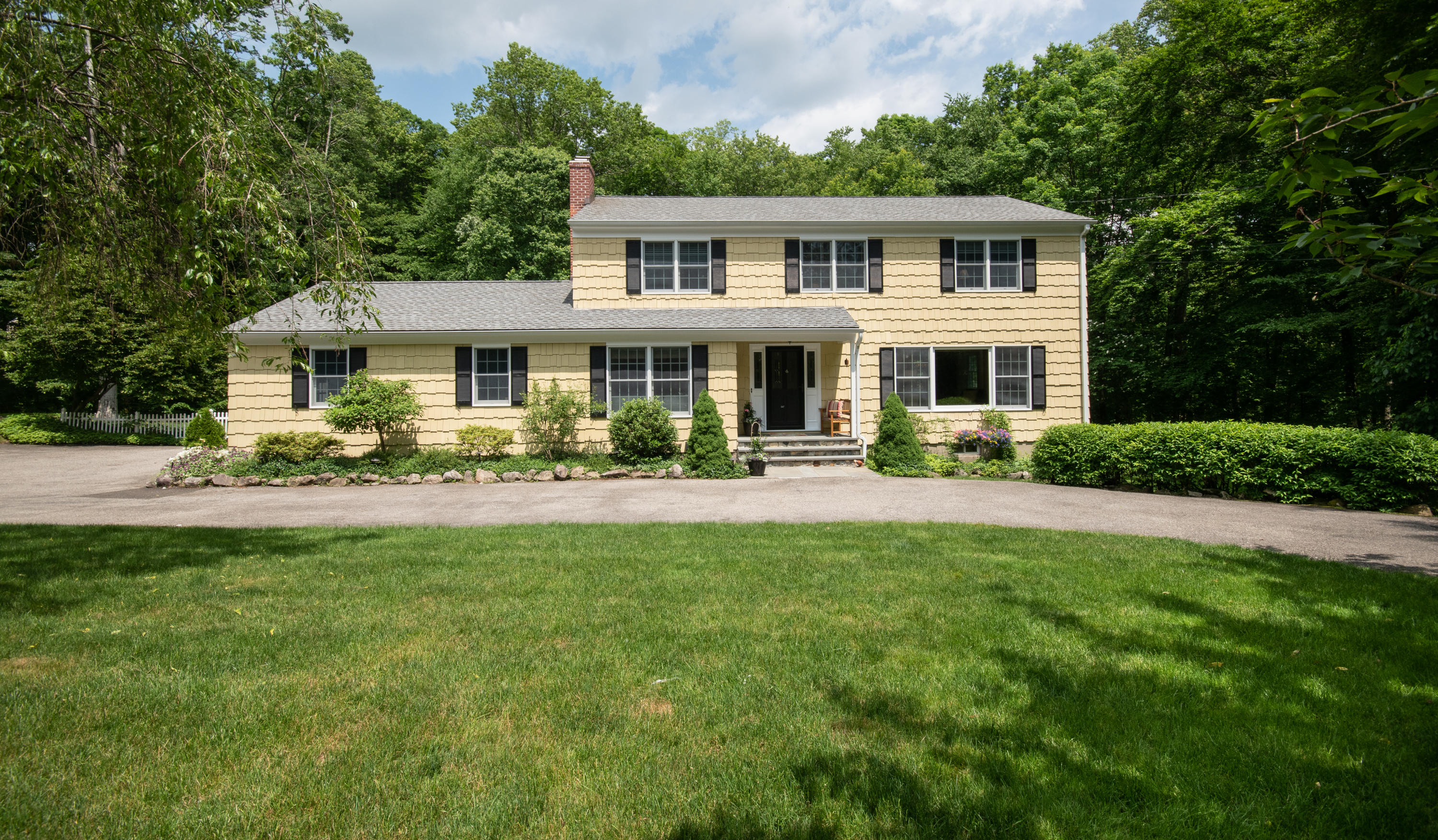 71 Rocky Brook Road New Canaan, CT 06840 - Photo 1 of 28 a front view of a house with yard and green space