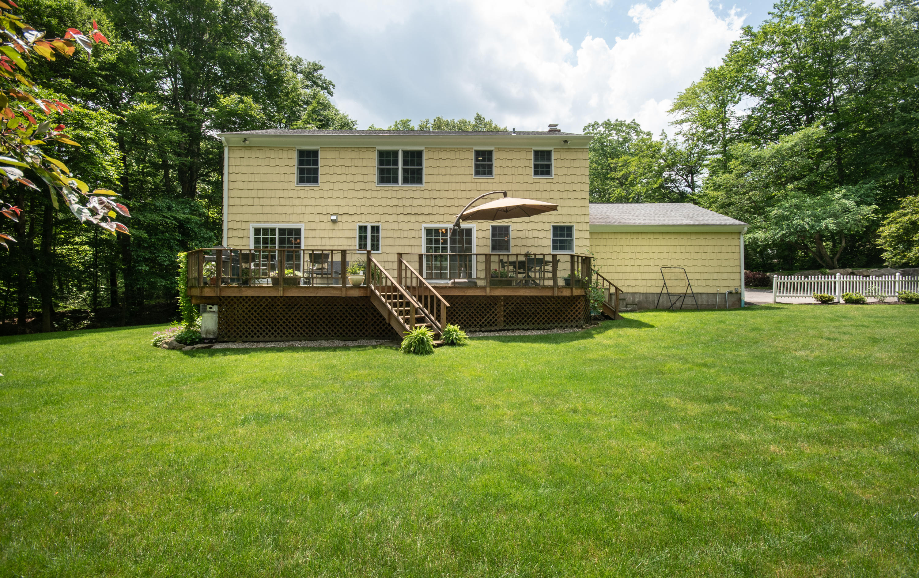 71 Rocky Brook Road New Canaan, CT 06840 - Photo 21 of 28 a front view of a house with a yard