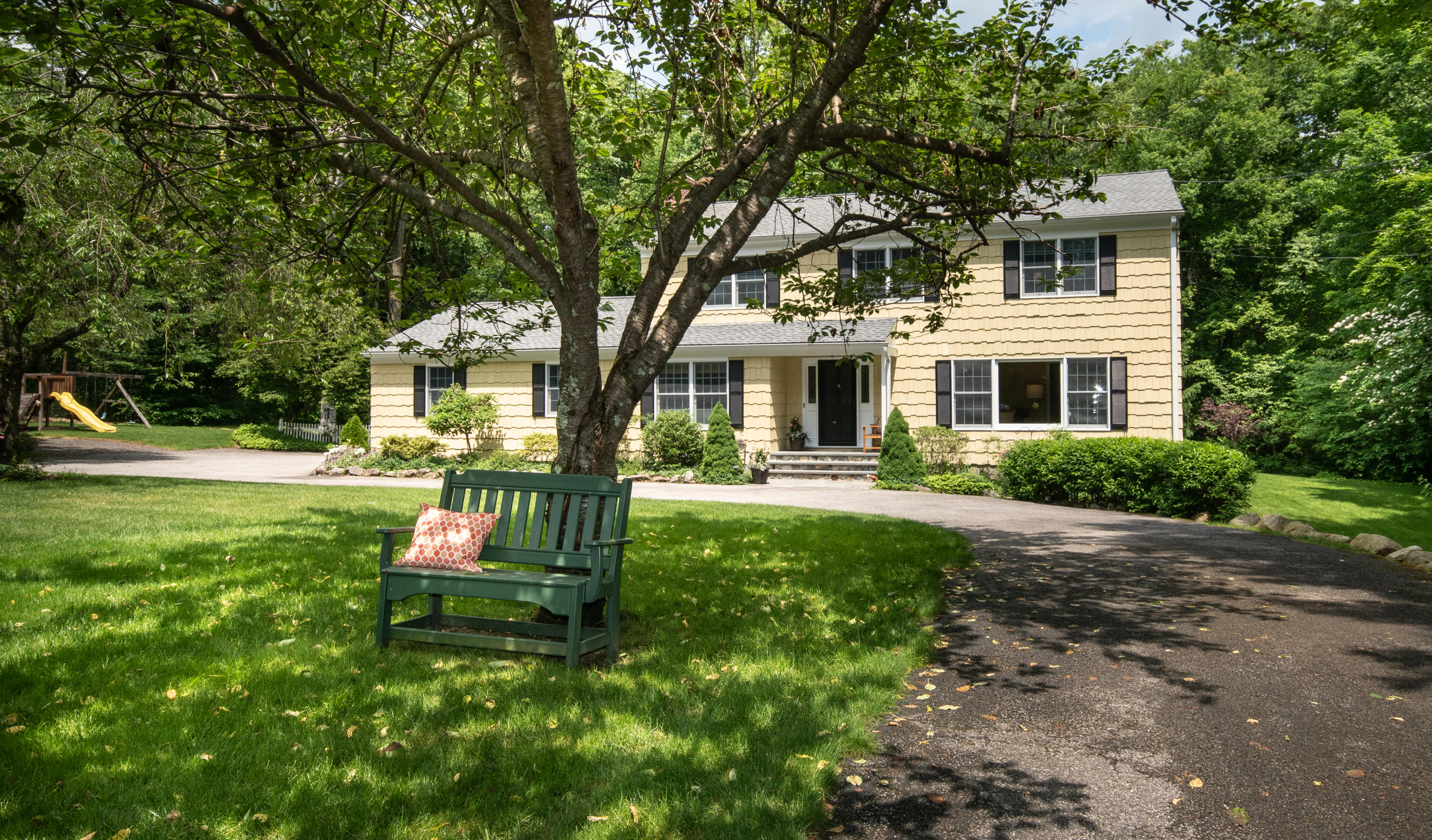 71 Rocky Brook Road New Canaan, CT 06840 - Photo 28 of 28 a front view of a house with yard and green space