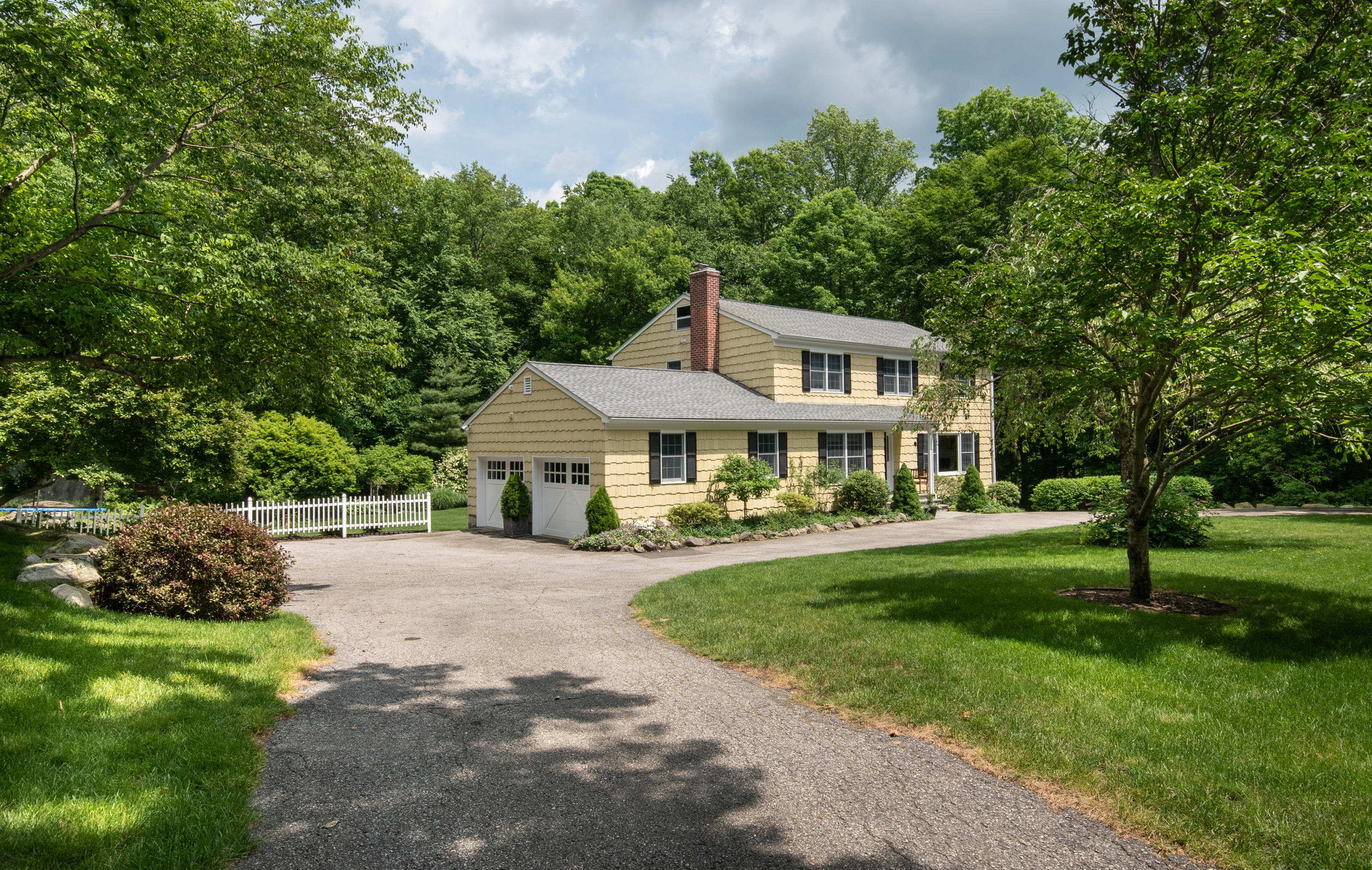 71 Rocky Brook Road New Canaan, CT 06840 - Photo 3 of 28 a front view of a house with a garden