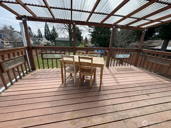 a view of a patio with dining table and chairs with wooden floor