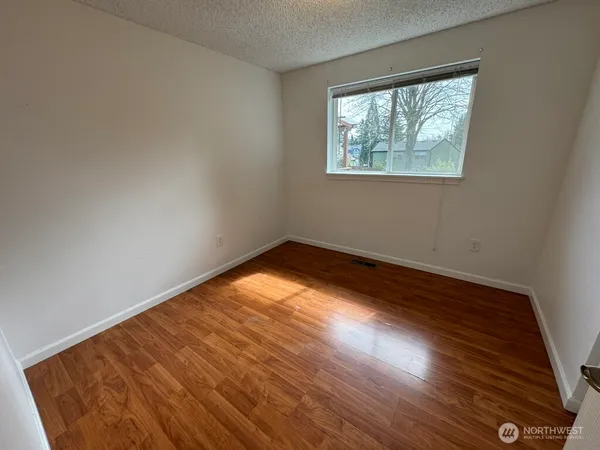 a view of empty room with wooden floor
