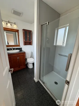 a bathroom with a granite countertop sink toilet and shower